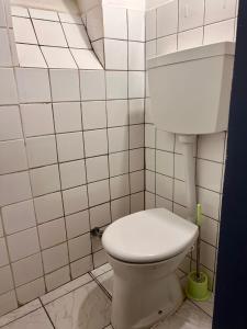 a bathroom with a toilet in a white tiled wall at Luxus Apartment in Vienna