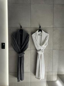 - deux serviettes accrochées au mur dans la salle de bains dans l'établissement Les secrets d'Eros - DAX, à Dax