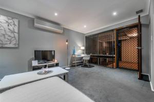 Cette chambre comprend un lit, une télévision et une table. dans l'établissement Modern Stylish House in Craigie, à Perth