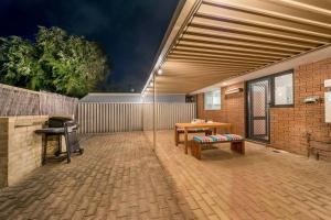 un patio avec une table, un banc et un grill dans l'établissement Modern Stylish House in Craigie, à Perth