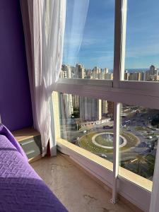 a bedroom with a window with a view of a city at Neptuno View 22 in Benidorm