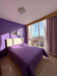 a purple bedroom with a purple bed and a window at Neptuno View 22 in Benidorm