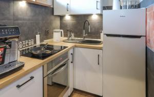 a kitchen with white cabinets and a sink and a refrigerator at Apartamenty Ty i Ja in Grodziec