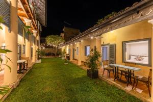 a courtyard at night with a table and chairs at The Dutch Bungalow in Galle