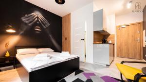 ein Schlafzimmer mit einem Bett mit einer Hand an der Wand in der Unterkunft Flatbook - City Center Apartments Waterlane Vintage with Gym in Danzig