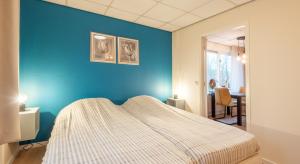 - une chambre avec un mur bleu et un lit dans l'établissement Appartementen Zuiderstrand Zoutelande, à Zoutelande