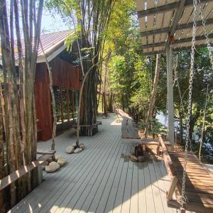 a wooden walkway with benches and trees at Teak@Teak in Ban Cha-om