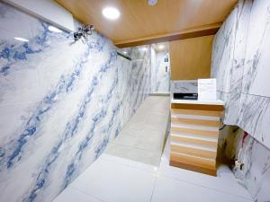 bagno con pareti in marmo bianco e blu di StarQ Hotel Bukit Bintang a Kuala Lumpur