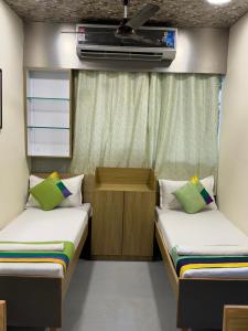 Kleines Zimmer mit 2 Betten und einem TV in der Unterkunft ZEST STAYS - IIT in Mumbai