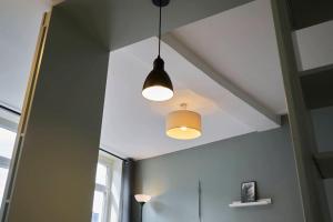 a room with two lights hanging from a ceiling at Lille Train station nice studio in Lille +28 photos