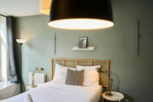 een slaapkamer met een bed met een groot licht erboven bij Lille Train station nice studio in Lille