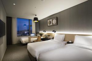 a hotel room with two beds and a desk at Arirang Hill Hotel Dongdaemun in Seoul