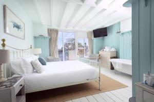 1 dormitorio con cama, bañera y lavamanos en Lulworth Cove Inn, en Lulworth Cove