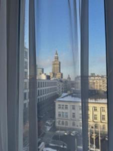 een raam met uitzicht op de skyline van de stad bij SCSK Żurawia in Warschau