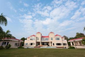 a large white house with a red roof at BluSalzz Collection - Siddha Wellness Village, Faridabad - Haryana in Faridabad