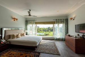1 dormitorio con cama grande y ventana grande en BluSalzz Collection - Siddha Wellness Village, Faridabad - Haryana, en Faridabad