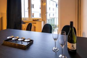 ハノーファーにあるAufzug Balkon 75m2 Zentralのワイン1本とグラス2杯付きのテーブル