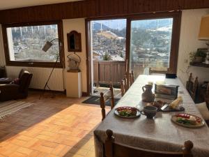 a dining room with a table and a large window at Chalet familial à Megève, vue sur le village in Megève