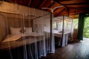 a bedroom with a canopy bed with mosquito nets at INN On The Tree Eco Resort Sigiriya in Sigiriya