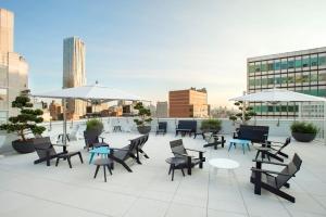 a rooftop patio with tables and chairs and umbrellas at FiDi 1BR w Gym WD nr S St Seaport NYC-536 in New York