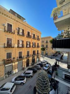 a city street with cars parked in front of buildings at Palazzo Gallo in Palermo