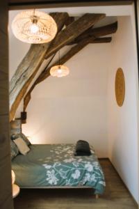 a bedroom with a bed in a room with wooden beams at gîte les Blés Dorés in Corgengoux