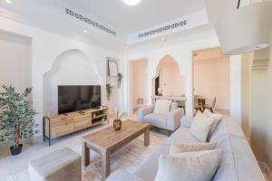 - un salon avec un canapé et une télévision dans l'établissement Traditional 2 Bedroom with Dubai Fountain View, à Dubaï