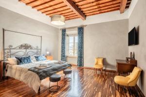 a bedroom with a bed and a wooden floor at Busdraghi Luxury Apartment in Lucca