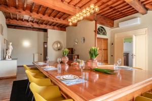 a dining room with a long table and yellow chairs at Busdraghi Luxury Apartment in Lucca