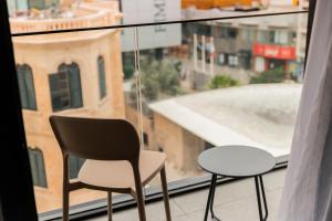 two chairs and a table on a window sill at The Londoner Hotel St. Julian's in St. Julianʼs