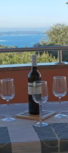 - une bouteille de vin assise sur une table avec 2 verres à vin dans l'établissement Apartman Vista Mare, à Pula