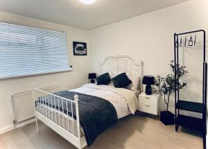 a bedroom with a white bed and a window at Entire 5 bedroom detached house free Parking 5 mins driving to Bicester Village in Bicester