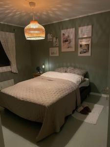 a bedroom with a bed and a chandelier at Bestemors hus - med kystnær beliggenhet in Fredrikstad