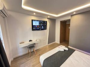 Habitación con cama y TV en la pared. en Futurotel Granada Dreams en Granada