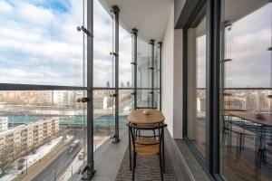 Una mesa en una habitación con ventanas grandes. en Apartamenty Wola Tower, en Varsovia