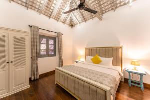 a bedroom with a bed and a ceiling fan at The Dutch Bungalow in Galle