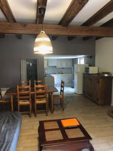 cocina y sala de estar con mesa y sillas en Maison à la ferme avec Pêche, en Roumégoux
