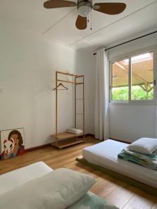 a bedroom with two beds and a ceiling fan at Séjour zen dans l'intense sud sauvage de l'île in Saint-Joseph