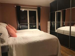 1 dormitorio con cama blanca y espejo grande en Top floor apartment in Stavangers best area! en Stavanger