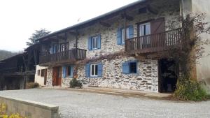 an old stone house with blue windows and balcony at Chez Sagaret in Chein-Dessus
