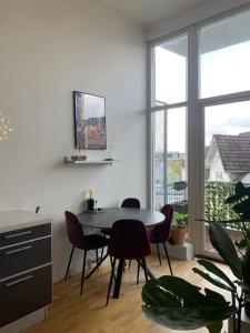 a dining room with a table and chairs and a window at Top floor apartment in Stavangers best area! in Stavanger