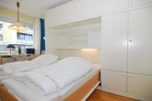 una camera da letto con armadi bianchi e un letto bianco di Metropol, Whg 61a, Landseite a Westerland