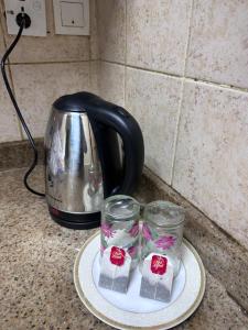 una tostadora y dos vasos en un plato en un mostrador en Studio for rent en Ajman 