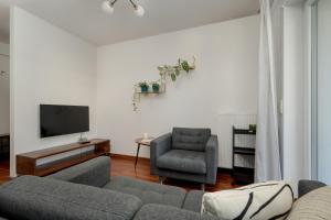 sala de estar con sofá, TV y silla en Black and Brown Apartment with Free Parking and Furnished Balcony in Wrocław by Renters en Breslavia