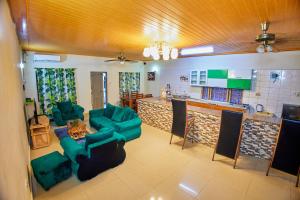 a living room with green furniture and a kitchen at Diani Home Stays in Diani Beach