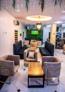 a lobby with couches and a tv on a wall at Chillers Hotel and Suites in Aiyetoto-Asogun
