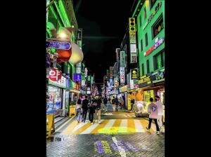 a city street at night with people walking on the street at Super quiet Dry bath floor OLED TV Closet room in Seoul +4 photos