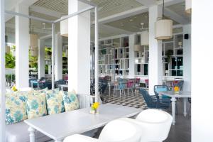 a patio with white tables and chairs and a table at The Nai Harn in Nai Harn Beach