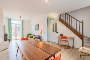 uma sala de estar com uma mesa de madeira e uma escada em 4 bedroom house with garden em Marcq-en-Baroeul