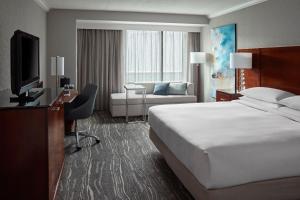 um quarto de hotel com uma cama, uma secretária e uma televisão em Halifax Marriott Harbourfront Hotel em Halifax
